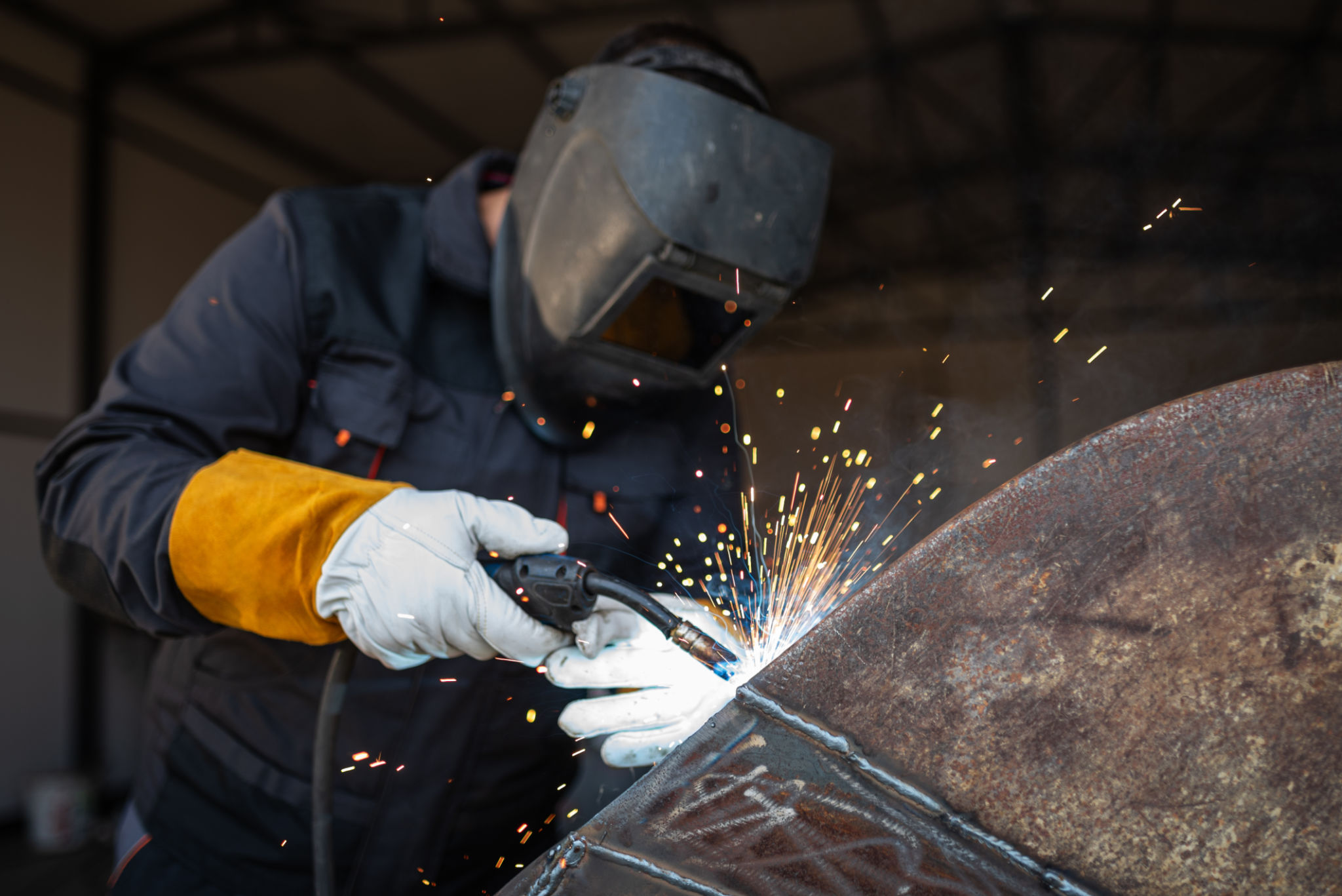 Metal worker welding steel structure with sparks flying Metal worker welding steel structure with sparks flying