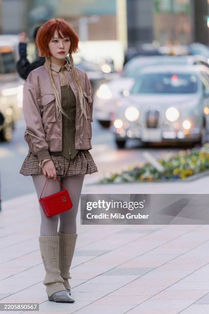 Guest is seen wearing a beige jacket, dress, corset top, tights, red Dior bag, beige shoe during Rakuten Tokyo Fashion Week A/W 2025 on March 19,...