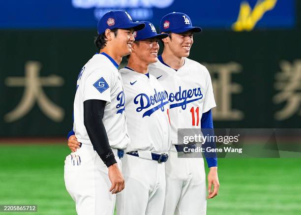Roki Sasaki, Shohei Ohtani and Yoshinobu Yamamoto of the Los Angeles Dodgers pose for a photo on the field after the game against the Los Angeles...