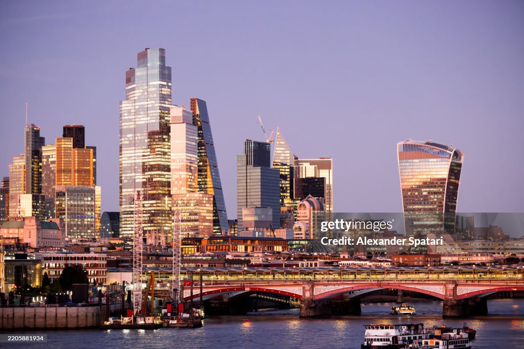 City of London illuminated skyline at dusk, London, England, UK