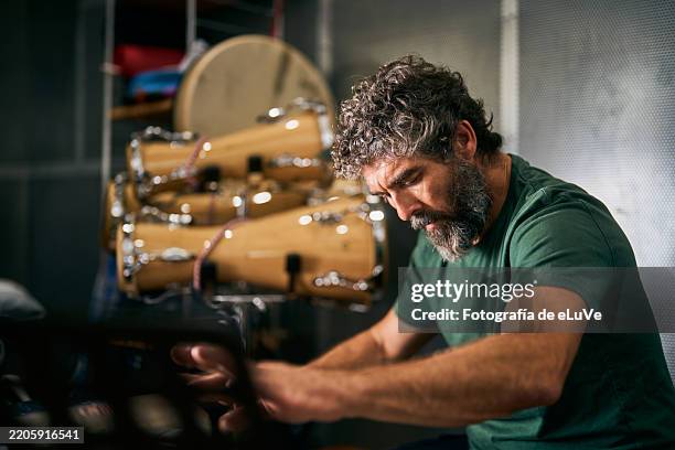 musician concentrating while playing bongos in his studio - latin music stock pictures, royalty-free photos & images