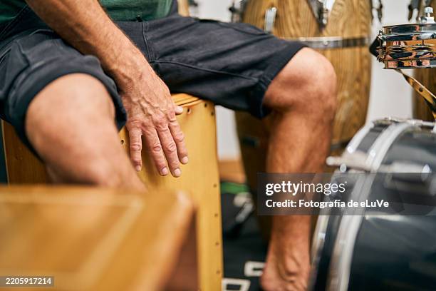 musician rehearsing rhythms on cajon in his study - improv stock pictures, royalty-free photos & images