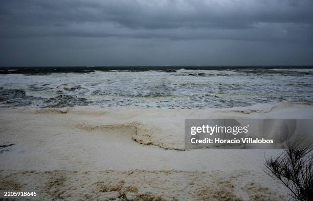 Sea foam forms as the ocean is agitated by wind and waves at the deserted Carcavelos Beach on late afternoon during "Martinho" depression on March 19...