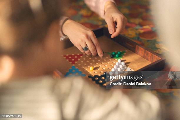 family connection. multigenerational family plays board game - bordspel stockfoto's en -beelden