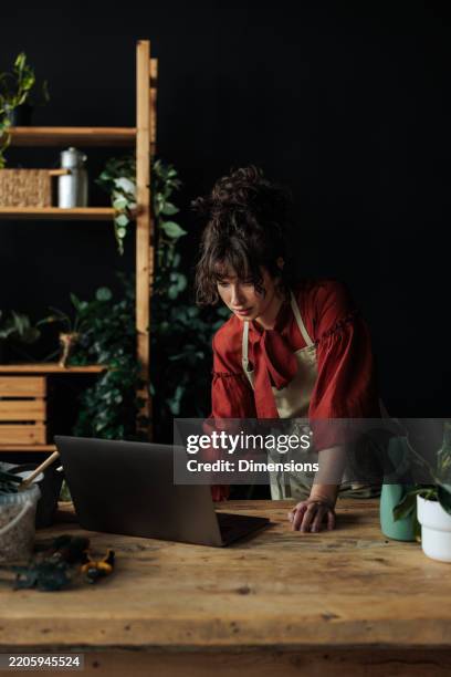 woman receiving orders online in her flower shop - social media marketing stock pictures, royalty-free photos & images