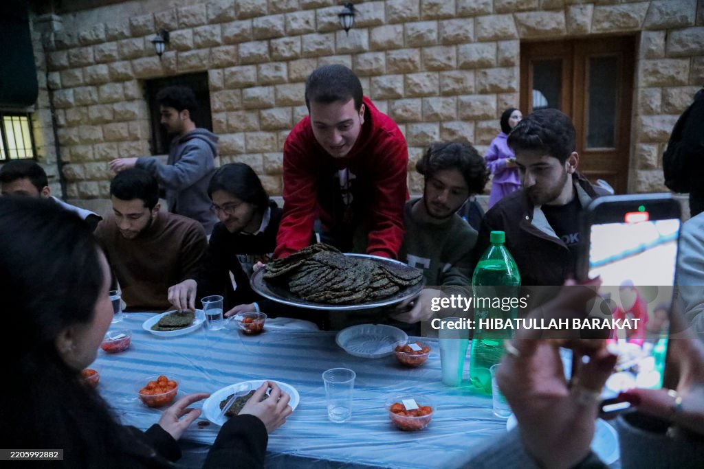 Fasting Rituals A group of young people sit at a table and sample traditional dishes ...