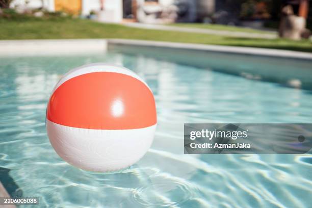 bola de playa flotando en la piscina del resort - flotar sobre agua fotografías e imágenes de stock