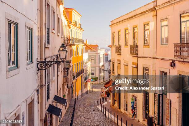 sunny streets of alfama, lisbon, portugal - lissabon stockfoto's en -beelden