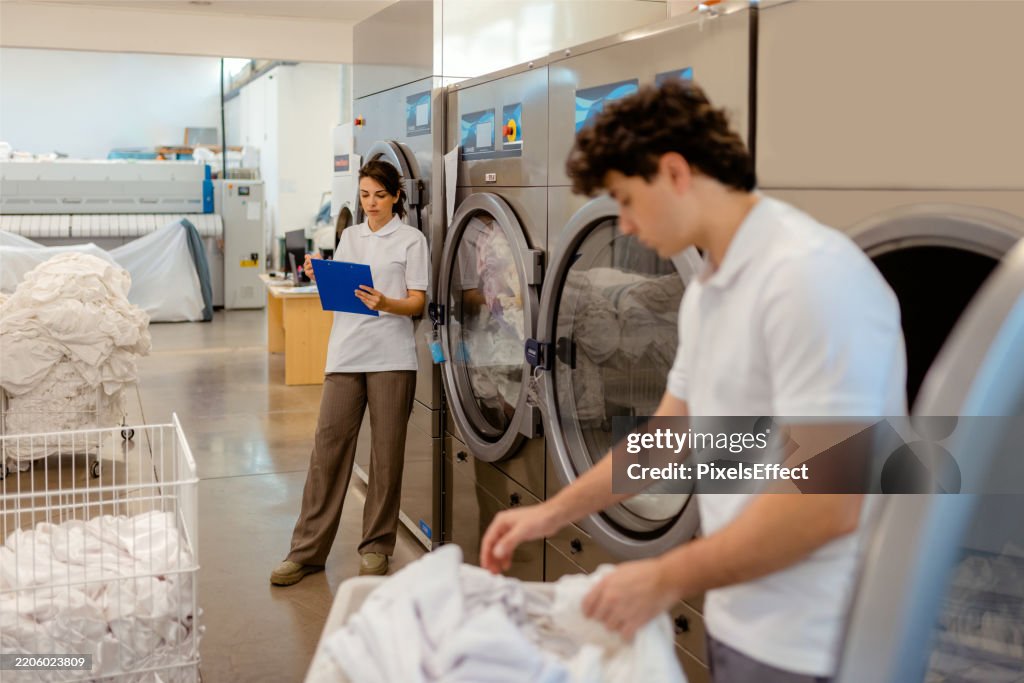 Young Entrepreneurs: One with Clipboard, One with Laundry
