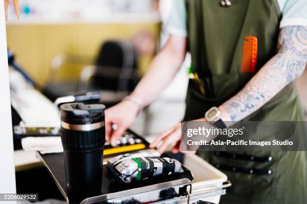 asian male professional barber arranging his tools in hair salon. - scissors position stock pictures, royalty-free photos & images