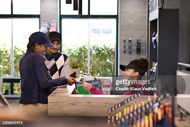 receptionist giving loyalty program coupon to customer - lealdade imagens e fotografias de stock