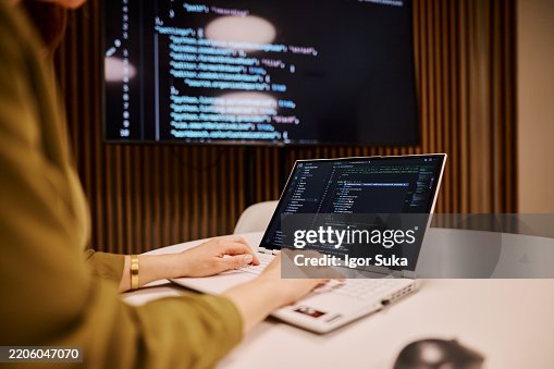 Computer programmer writing code on a laptop in the office Computer programmer writing code on a laptop in the office