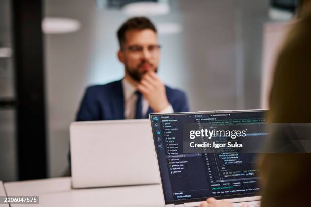 software developers working on code on a laptop in the office - java code stock pictures, royalty-free photos & images