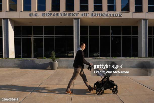 Person pushes a stroller past the U.S. Department of Education on March 20, 2025 in Washington, DC. U.S. President Donald Trump is preparing to sign...