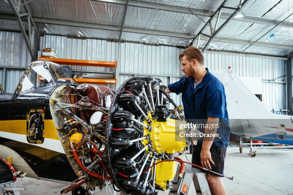 Young engineer working on airplane engine