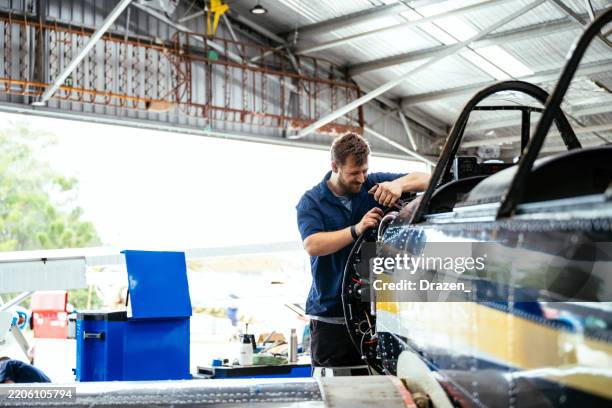 jeune ingénieur travaillant sur les moteurs d’avion - aviation-générale photos et images de collection