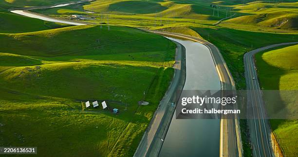 high angle photo of grassy hills, rural highways, and the california aqueduct - altamont pass - aqueduct stock pictures, royalty-free photos & images