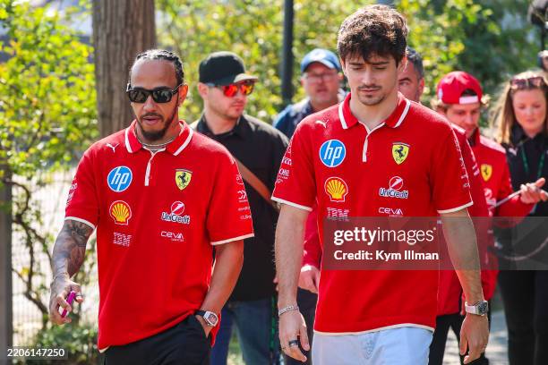 Lewis Hamilton of Great Britain and Ferrari and Charles Leclerc of Monaco and Ferrari walk in the paddock during practice/Sprint qualifying ahead of...