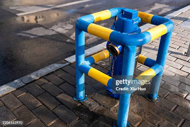 intelligent fire hydrants equipped with guardrails on urban roads - blue fire extinguisher stock pictures, royalty-free photos & images