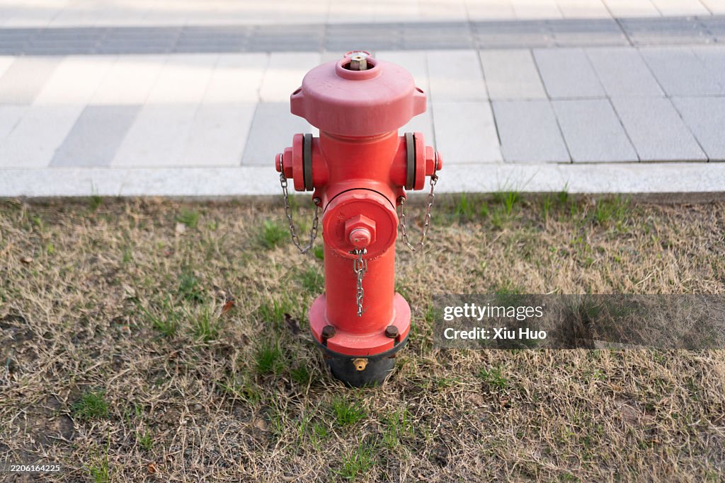 Red fire hydrant next to the city road