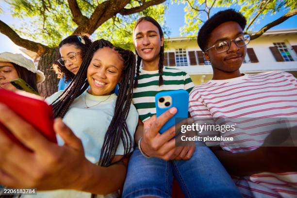gruppe unterschiedlicher teenager der generation z, die smartphones gemeinsam im freien nutzen - druck durch gleichaltrige stock-fotos und bilder