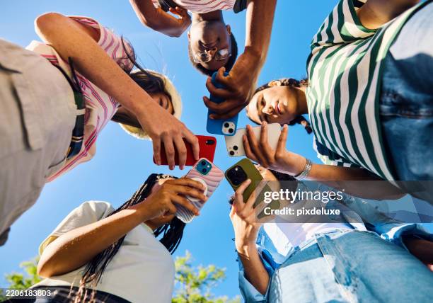 grupo de adolescentes de la generación z usando teléfonos inteligentes juntos al aire libre - adolescente fotografías e imágenes de stock