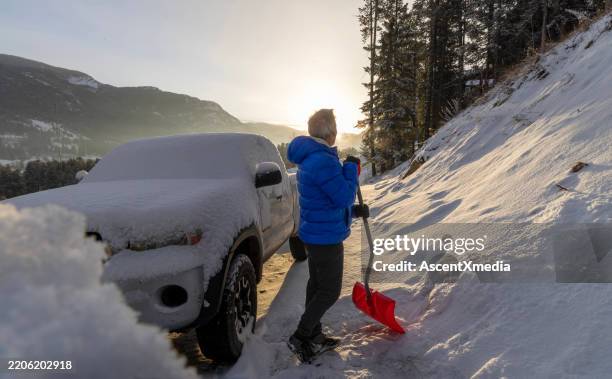 mature man shovels fresh snow from driveway - snowdrift stock pictures, royalty-free photos & images