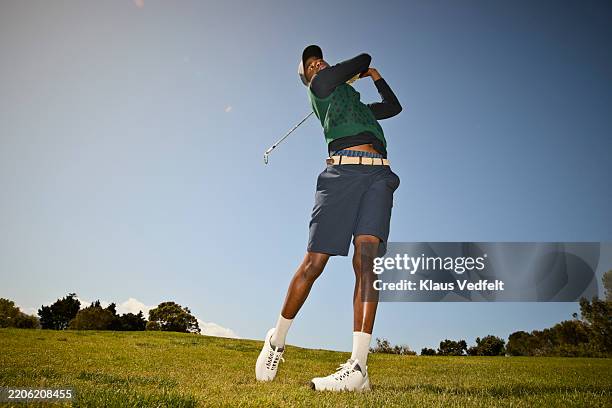 male golfer teeing off with golf club at course - golf sport stockfoto's en -beelden