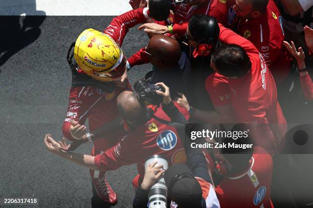 Sprint winner Lewis Hamilton of Great Britain and Scuderia Ferrari celebrates in parc ferme with his father Anthony Hamilton and his team during the...