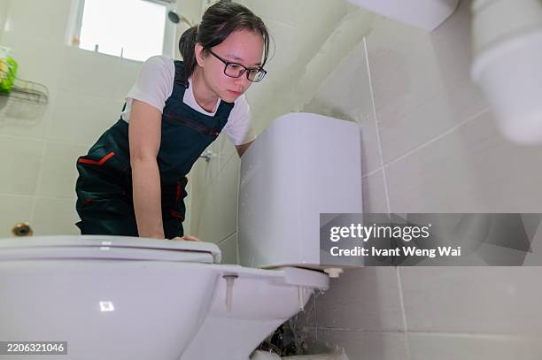 asian chinese young female check water closet leaking issue for repair and change part stock photo - pipe replacement stock pictures, royalty-free photos & images