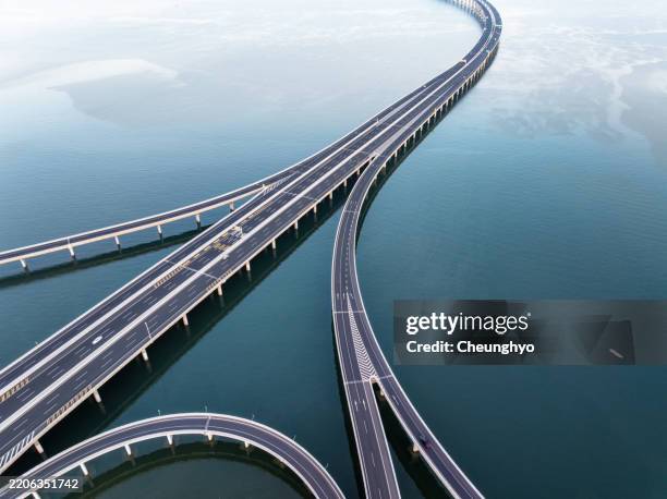 drone aerial view of jiaozhou bay bridge of qingdao, shandong province, china - balkengerüst stock-fotos und bilder