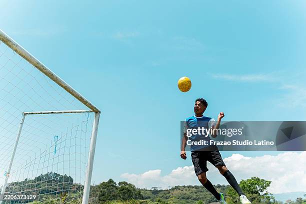 jogador de futebol cabeceando a bola no campo de futebol - cabeçada - fotografias e filmes do acervo