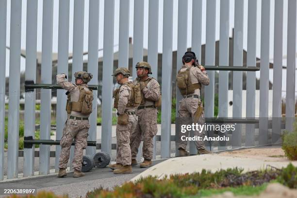 United States Marine Corps troops patrol, weld and install concertina wire along the US-Mexico Tijuana-San Diego beach border area as seen from...
