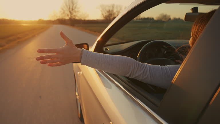 https://media.gettyimages.com/id/2206444020/video/rear-view-of-carefree-young-woman-driving-car-on-country-road-during-sunset-with-arm-out.jpg?b=1&s=640x640&k=20&c=CuhgkcQSqQcb-3K_GrWopSbrD-3EZZJrge0cO9ob6ks=