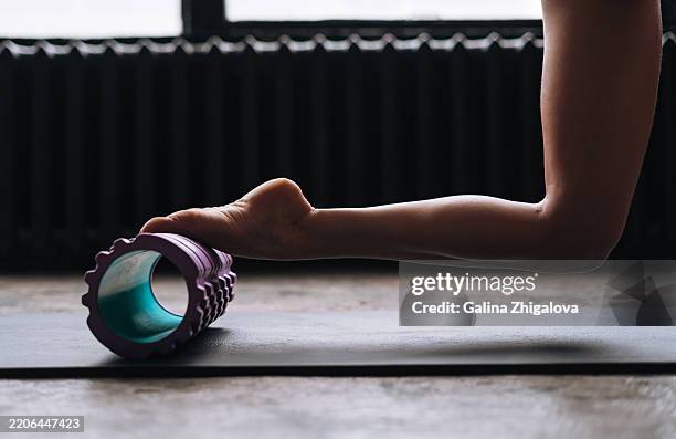 young woman in sportswear with pilates roller doing exercises in the studio - foam roll stock pictures, royalty-free photos & images