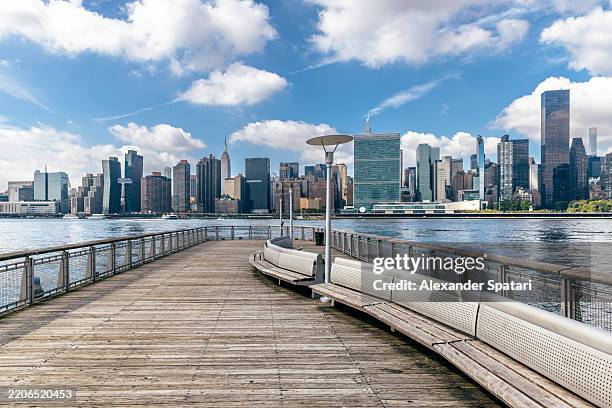 pier with view of manhattan skyline in gantry plaza state park in queens, new york city, usa - queens day stockfoto's en -beelden