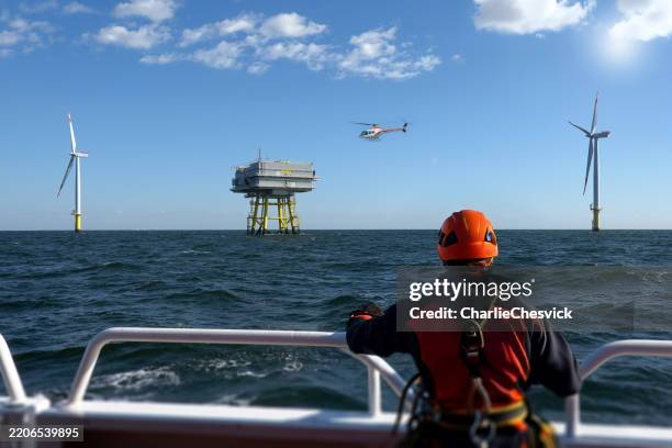 offshore technician observing landing helicopter and wind_farm from deck - offshore wind farm workers stock pictures, royalty-free photos & images