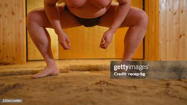 sumo wrestler practicing in dohyo sumo wrestling ring - sumo wrestling stock pictures, royalty-free photos & images