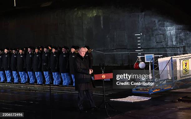 Russian President Vladimir Putin walks past Naval officers, while visiting a military base of nuclear submarines on March 27 in Murmansk, Russia....