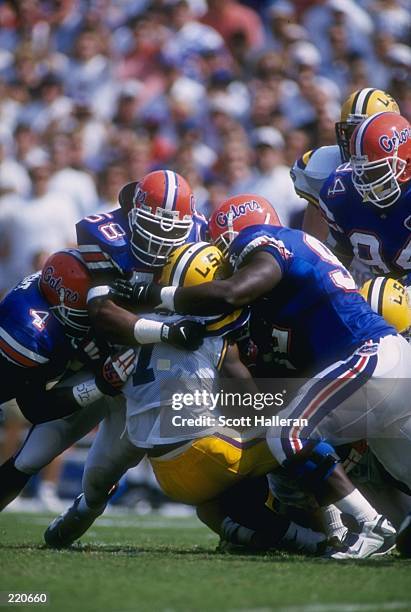 Strong safety Lawrence Wright, linebacker Johnny Rutledge and defensive tackle Reggie McGrew of the Florida Gators tackle tailback Rondell Mealey of...