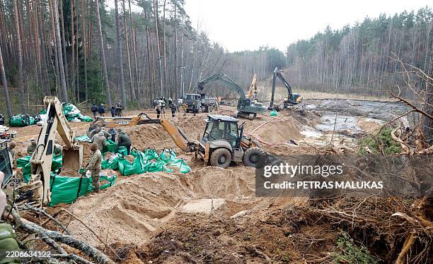 Military personnel work at the site of a rescue operation for missing US soldiers at Pabrade training ground, in Lithuania, on March 28, 2025....