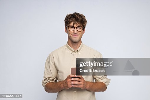Portrait of smiling young man holding smart phone Portrait of smiling young man holding smart phone
