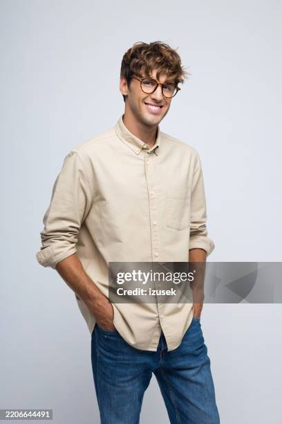 studio portrait of handsome young caucasian male - beige shirt stock pictures, royalty-free photos & images