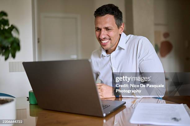 man attending an online job interview from home - document retention stock pictures, royalty-free photos & images