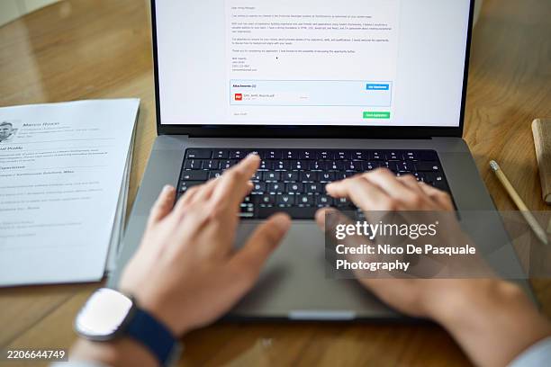man attaching his resume while applying for a job offer online with his laptop from home - document retention stock pictures, royalty-free photos & images