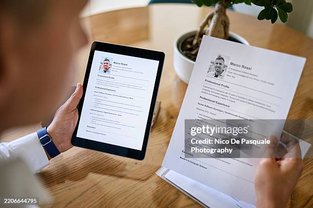 man creating a digital resume on a tablet at home - cv bildbanksfoton och bilder