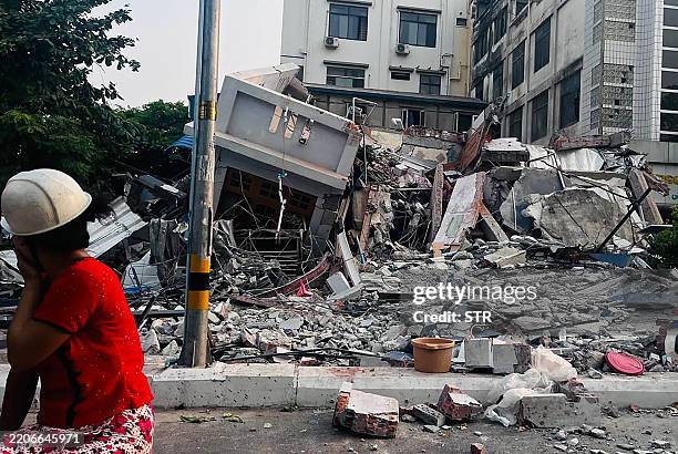 Resident looks on next to a collapsed building in Mandalay on March 28 after an earthquake in central Myanmar. A powerful earthquake rocked central...