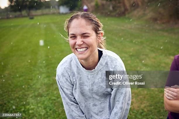 portrait of happy female rugby player in rain - parpadear fotografías e imágenes de stock