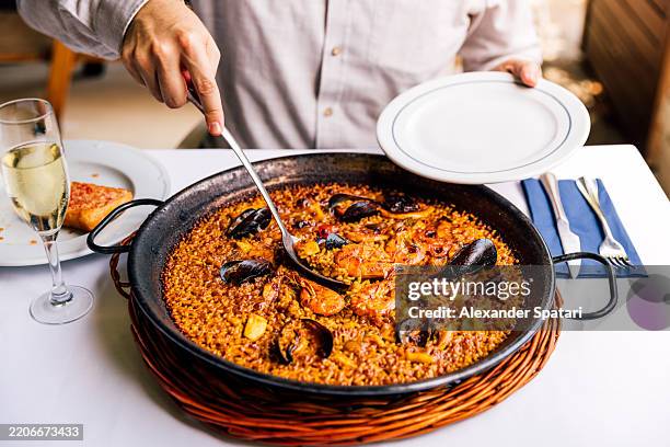 man eating seafood paella at a restaurant - spaanse cultuur stockfoto's en -beelden