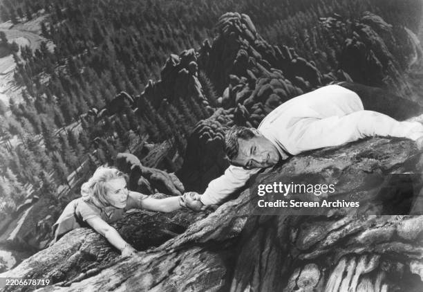 Cary Grant clings to Eva Marie Saint as they climb Mount Rushmore in a scene from Alfred Hitchcock's 'North by Northwest' 1959.